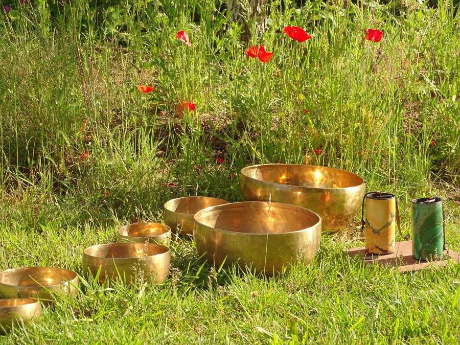 Klangschalen auf Wiese mit Mohn